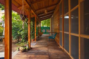 une terrasse couverte d'une maison avec une chaise bleue dans l'établissement Casona H, à Puerto Escondido