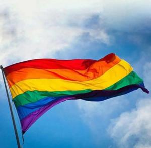 una bandera de color arco iris ondeando en el cielo en L&M Housing Apartamentos y casa, en Búzios