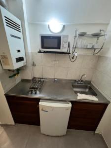 a small kitchen with a sink and a microwave at Departamento frente a la CASA HISTÓRICA DE TUCUMAN in San Miguel de Tucumán