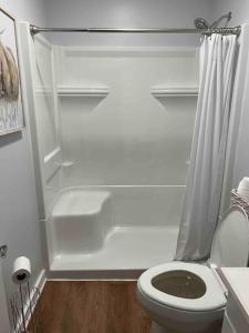 a white bathroom with a toilet and a shower at Cozy Cabin, minutes from Lost River State Park in Mathias