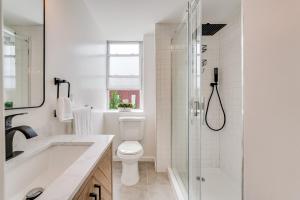 a white bathroom with a toilet and a shower at Jersey City Monthly Boutique 20 Min to NYC in Jersey City