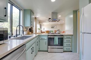 uma cozinha com armários verdes e um lavatório em Modern Sacramento Townhome with Patio! em Sacramento