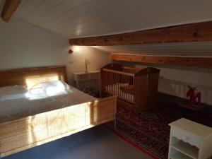 una camera con un grande letto e una culla di Maison Les Aigles du Ventoux, Piscine, Isle sur Sorgue / Pernes les Fontaines a Pernes-les-Fontaines