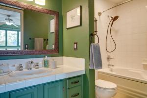 a bathroom with a sink and a tub and a mirror at Charming Anchorage Home with Private Hot Tub! in Anchorage