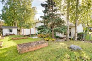 a yard with a garden in front of a house at Charming Anchorage Home with Private Hot Tub! in Anchorage