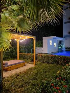 un patio trasero con cama y piscina por la noche en Hotel Puerto Triunfo en Doradal