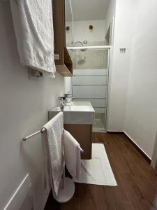 a white bathroom with a sink and a mirror at B&B la casa di Polly in Falconara Marittima