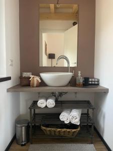 a bathroom with a sink and a mirror and towels at La Marmotta COUNTRY RELAIS sul lago in Anguillara Sabazia