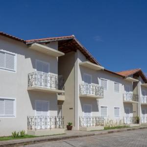 een wit appartementencomplex met balkons in een straat bij Apart Sol Nascente in Itatiaia
