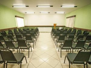 a large room with chairs and a table in it at GoldMen Select Maringá in Maringá