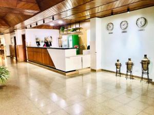 a lobby with clocks on the wall and a counter at GoldMen Select Maringá in Maringá +41 photos