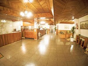 a large room with wooden ceilings and a large room with furniture at GOLDMEN HOTEL MARINGÁ in Maringá