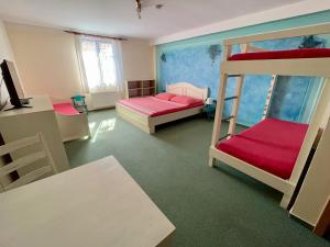 a room with two bunk beds and a desk at Johannova Bouda in Vrchlabí