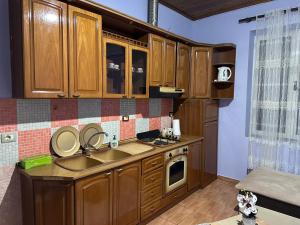 una cocina con armarios de madera y fregadero en Moonlight Apartment, en Shkodër