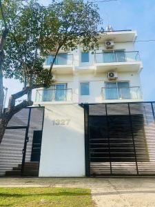 un edificio blanco con puerta y garaje en Tigre Urban Suites en Tigre