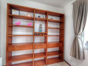a wooden book shelf in a room with a curtain at Ap Brisa do Mar Praia da Costa in Vila Velha