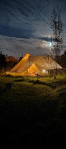 a large tent in a field at night at Au Pied Du Trieu, the glamping experience in Labroye