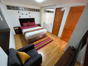 Cusco Rooms في كوسكو: غرفة نوم صغيرة مع سرير وأريكة