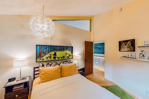 1 dormitorio con cama y lámpara de araña en The Island Treehouse en Eastsound