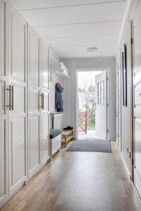 a hallway with white walls and a door with a closet at comfortable room in a unique house at vikingavägen 75 in Gävle