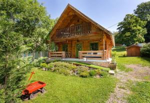 a log cabin with a red wagon in front of it at Mannana házikó in Szokolya