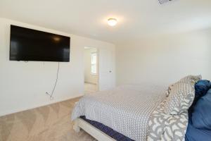 um quarto com uma cama e uma televisão de ecrã plano em Spring Retreat with Private Yard and Charcoal Grill! em Spring