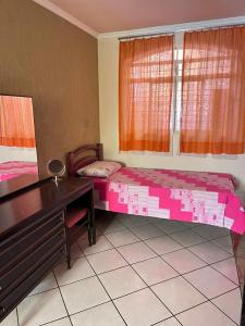a bedroom with a bed and a desk in it at Pousada Lopes na Fama in Goiânia