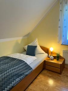 ein Schlafzimmer mit einem Bett und einem Tisch mit einer Lampe in der Unterkunft Ferienwohnung Heide in Freudenstadt