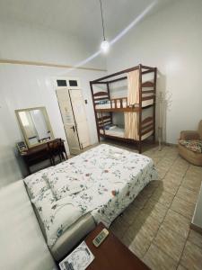a bedroom with a bed and a bunk room with a shelf at Aldeia Hostel in Manaus