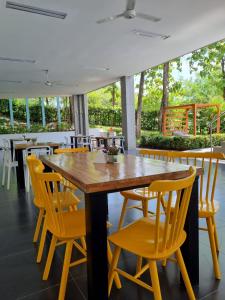 comedor con mesa de madera y sillas amarillas en Hotel Puerto Triunfo en Doradal