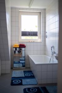 a bathroom with a tub and a window and towels at NB Katharinenviertel Zwei Zimmer Wohnung in Neubrandenburg