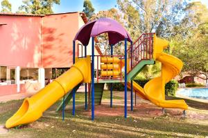 a playground with a slide next to a pool at Hotel Fazenda Bonjuá in Montes Claros