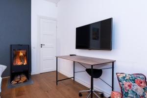 a living room with a table and a fireplace at Sunny Terrace Flat with AC Free WiFi Self Check In in Pärnu