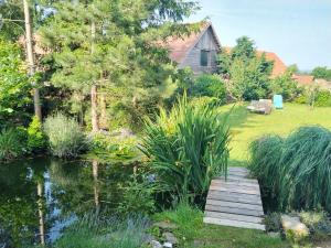 un jardín con un puente de madera sobre un estanque en Pohoda u Crhů Senožaty 