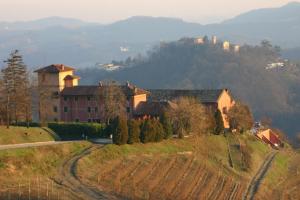 een groot huis op een heuvel met een weg bij Tenuta Tenaglia in Serralunga di Crea