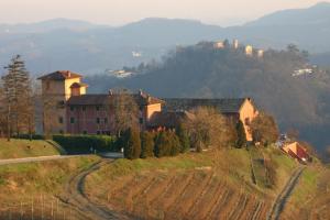 una grande casa su una collina con una strada di Tenuta Tenaglia a Serralunga di Crea