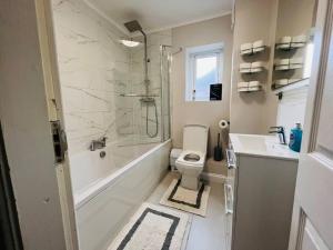 a bathroom with a toilet and a shower and a sink at Gytes Lane, Manchester with FREE Parking and FREE Wi-Fi in Manchester