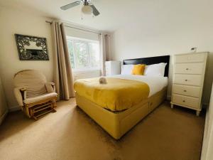 a bedroom with a yellow bed and a chair at Gytes Lane, Manchester with FREE Parking and FREE Wi-Fi in Manchester