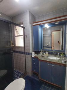 W łazience znajduje się umywalka, toaleta i lustro. w obiekcie Ap Brisa do Mar Praia da Costa w mieście Vila Velha