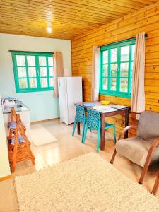 eine Küche mit einem Tisch und einem Kühlschrank in der Unterkunft Prana Guest House in Praia do Rosa