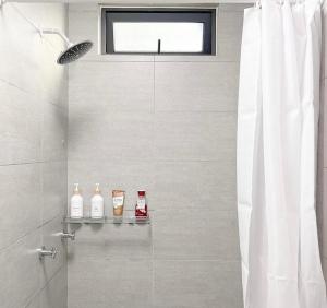 a bathroom with a shower with a white shower curtain at Krisa Scarlet’s Farmhouse in San Fernando