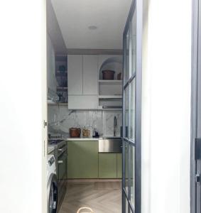 a kitchen with green and white cabinets and a sink at Krisa Scarlet’s Farmhouse in San Fernando