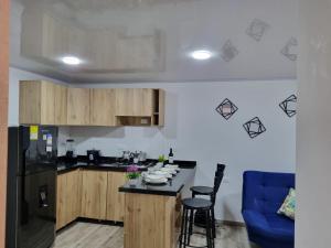 een keuken met houten kasten en een aanrechtblad bij Apartahotel AMARU in San Gil