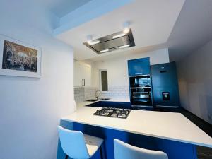 a kitchen with a white counter top and blue cabinets at Del Mar Apartment in Żebbuġ