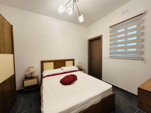 um quarto com uma cama com um saco vermelho em Del Mar Apartment! em Żebbuġ