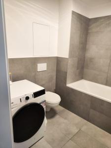 e bagno con servizi igienici, lavandino e vasca. di NEW Luxury 2 bedroom apartment, fully airconditioned, near the airport, FREE Parking a Bratislava