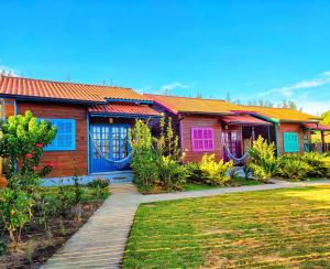 a house with a wooden walkway in front of it at Prana Guest House in Praia do Rosa