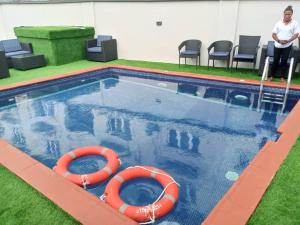 uma piscina com dois anéis de vida laranja em Hemistry em Ikeja