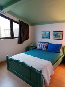 una camera con letto verde in una stanza con finestre di Varandas Miramar ad Angra do Heroísmo