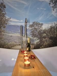 a wooden table with candles and a bottle of wine at El Pitijopo in El Gastor